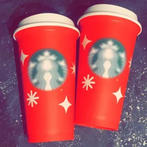 Close-up detail of 16oz red plastic coffee travel cup with white lid and snowflake decor.