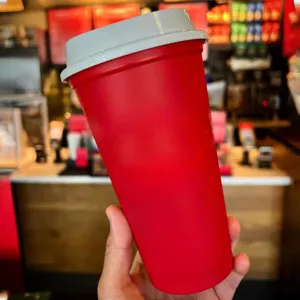 Red plastic coffee travel mug with white lid, 16oz portable cup detail view for daily use.