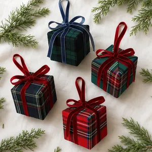 Detailansicht von Weihnachts-Schottenkaro-Geschenkbox-Hängeornamenten mit Samtschleifen.