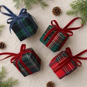 Nahaufnahme von weihnachtlichen Karo-Geschenkbox Hängeornamenten mit Samtschleifen und Tannendeko.
