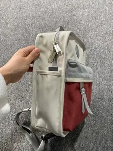 Rucksack Seitendetail aus Canvas mit praktischer Seitentasche und markenbesetztem Reißverschluss.