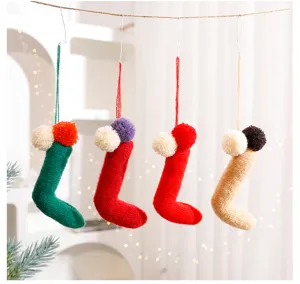 Detailed view of knitted Christmas sock ornaments with colorful pom poms for holiday decor.