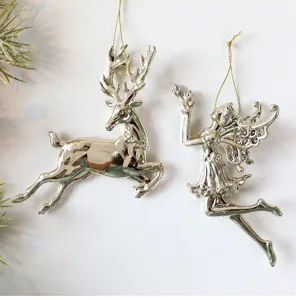 Detailaufnahme von silbernen champagnerfarbenen Acryl-Weihnachtsanhängern in Hirsch- und Feenform.