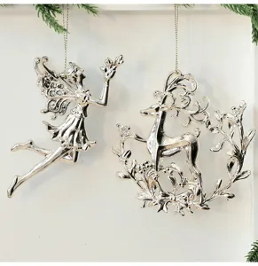 Detailansicht silberner Weihnachts-Hängeornamente mit Feen- und Renntier-Motiven und Tannendeko.