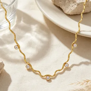 Collier ras de cou en acier inoxydable doré ondulé avec zircons brillants vue détaillée.