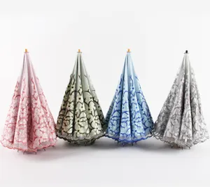 Detailed view of the folded double-layer lace embroidered sun umbrella with solid wood handle.