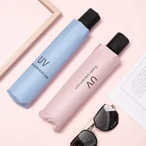 Closeup detail of folding UV protection umbrellas in blue and pink with black vinyl coating.