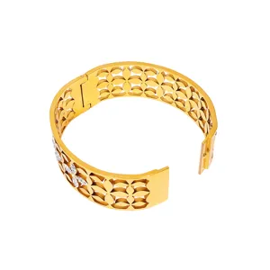 Detail shot of wide hollow clover cuff bracelet in gold finish with sparkling rhinestone inlay.