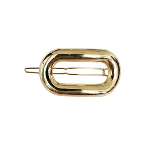 Dettaglio molletta per capelli ovale in metallo dorato, elegante design geometrico per donna.