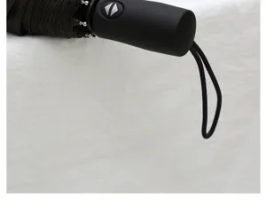 Close up of black three fold automatic umbrella handle with strap detail product shot