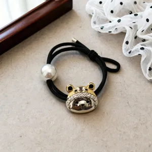 Elegant black elastic hair tie featuring a sparkling tiger head pendant and a glossy pearl bead detail.