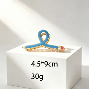 Detailed view of a creative pencil shaped hair claw clip in blue gold finish. 4.5x9cm.