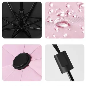 Compact three-fold umbrella detail, waterproof pink fabric, sturdy black ribs and sleek handle.