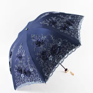 Élégant parapluie pliante bleu marine avec broderie florale complexe, dentelle et anti-UV.