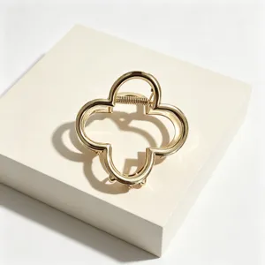 Gold four leaf clover metal hair claw clip detail shot, elegant hairpin accessory for women.