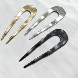 Vista di dettaglio di forcine per capelli a U minimaliste oro argento e nero, accessorio chic.