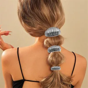 Dettaglio di polsini per capelli metallici argentati, accessorio per coda di cavallo.