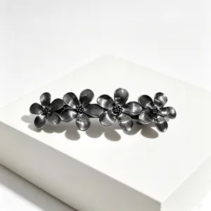 Primer plano detallado de la elegante horquilla floral de metal, con una textura muy fina.