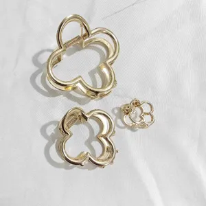 Gold four-leaf clover metal hair claw detail shot, elegant minimalist design for daily styling.