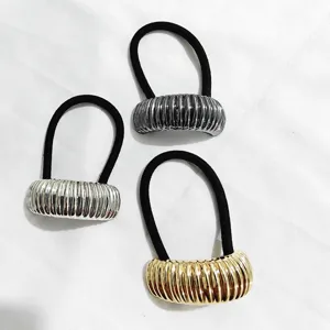 Primo piano di elastici per capelli semicircolari metallici in oro, argento e grigio scuro.