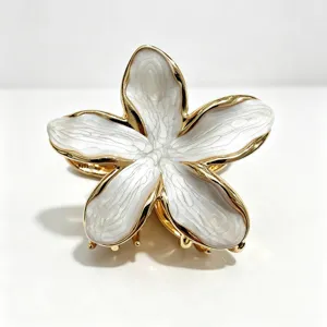 Dettaglio molletta per capelli frangipane, elegante design fiore bianco con bordo oro.