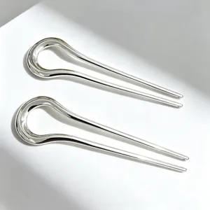 Detail shot of minimalist silver U-shaped hair forks, sleek alloy hair accessory for styling.