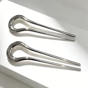 Detailed close-up of minimalist alloy U-shaped hair fork, sleek curved design for elegant buns.