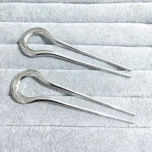Detailed view of simple silver alloy U-shaped hairpins, elegant hair fork on display tray.