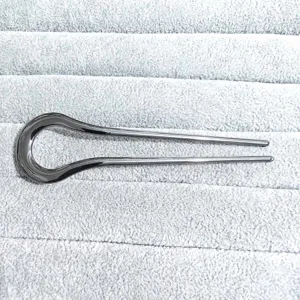 Minimalist dark alloy U-shaped hair fork detail view, elegant curved metal hairpin.