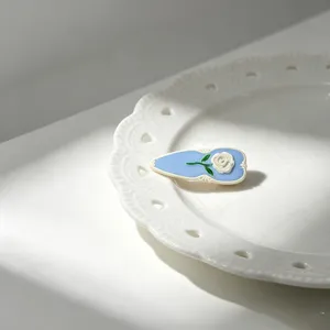 Detailed view of the French retro blue enamel hair clip featuring a white rose design.