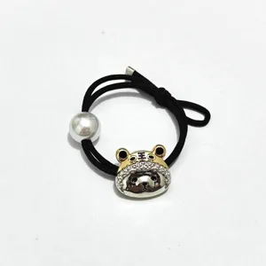 Black hair tie featuring a metallic tiger pendant with rhinestones and a chic pearl bead.