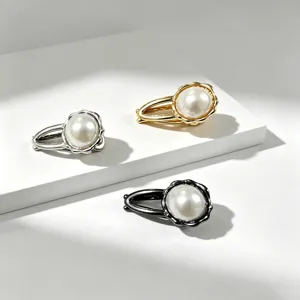 Dettaglio di fermagli per capelli con perle in metallo argento, oro e nero per frangia.