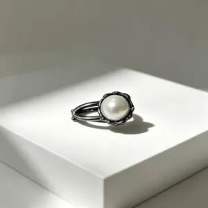 Dettaglio di una chicca forcina per capelli con perla e montatura in metallo bianco.