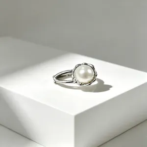 Elegante anello color argento con perla bianca luminosa dal design raffinato e chic.