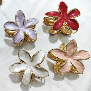 Set di 4 eleganti mollette per capelli a fiore con bordo dorato e smalto colorato.