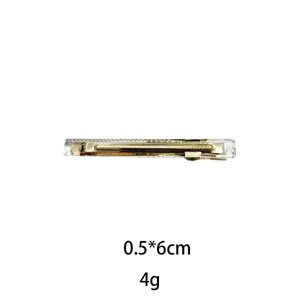 Detail shot of a Korean style gold metal hair clip with clear polka dot design, 0.5x6cm.