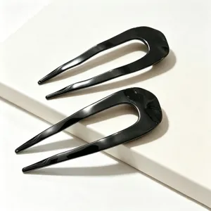 Primo piano dettagliato del bastoncino per capelli nero a U, accessorio minimalista.