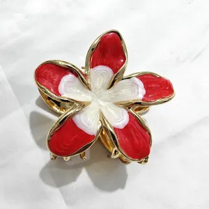 Dettagli della molletta per capelli a forma di fiore rosso e bianco, con bordatura dorata.