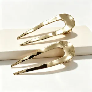 Dettaglio forcina per capelli a U dorata minimalista, elegante fermaglio per chignon.