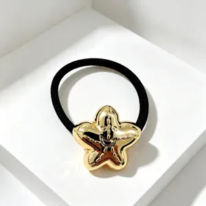Gedetailleerd beeld van gouden ster haarring met schattig lachende zeester voor paardenstaarten.