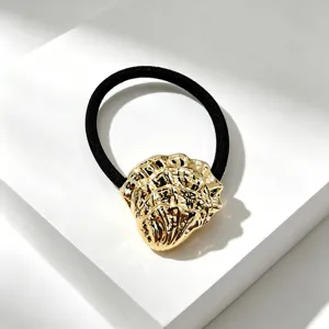Elegante gouden haarband met onregelmatige metalen bedel en duurzame zwarte elastiek.