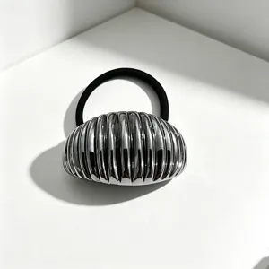 Primo piano dettagliato di un elastico per capelli semicircolare metallico minimal.