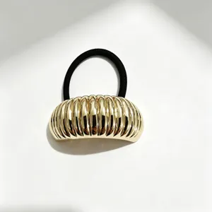 Dettaglio elastico per capelli geometrico oro metallico, accessorio coda di cavallo.