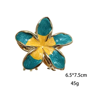 Primo piano dettagliato della molletta per capelli a fiore in smalto blu e giallo con bordo.