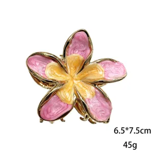 Dettaglio squisito del fermaglio per capelli frangipani con petali rosa e centro giallo lucido.