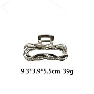 Detalles de la pinza de pelo de metal líquido irregular plateado con diseño hueco.