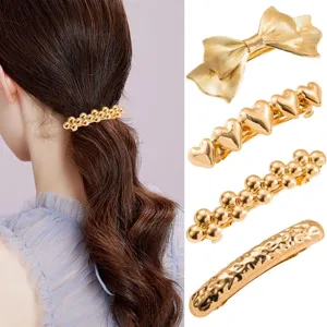 Gold metal hair clip set, elegant bow and heart bead spring clips for ponytail styling.
