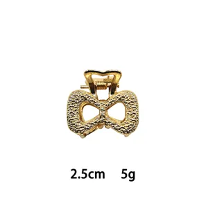 Detailed close-up of mini gold alloy hair claw clip, textured bow design, compact 2.5cm size.