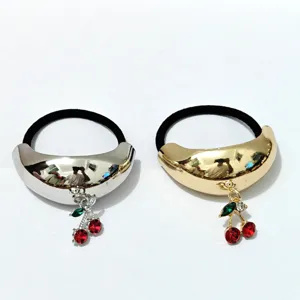 Metal crescent hair tie with rhinestone cherry pendant, shiny finish hair accessory detail.