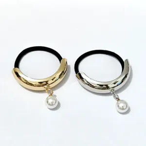 Detail of luxury metallic curved hair ties with pearl charms, gold and silver alloy hair accessories.